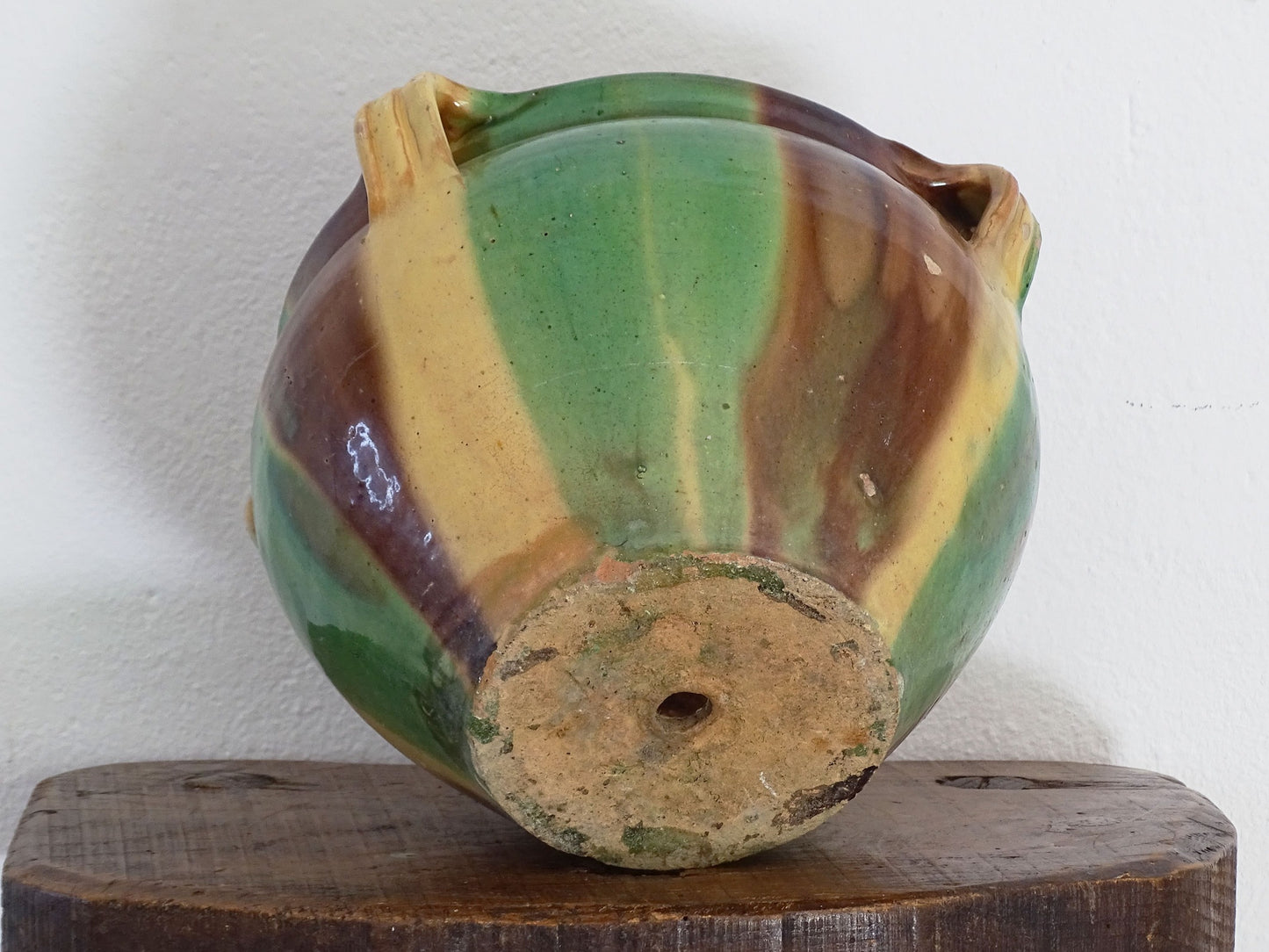 Antique French pottery planter or cache pot with a drip glaze stripe in yellow, green and brown. This earthenware terracotta pot has for handle and a timeworn appearance.