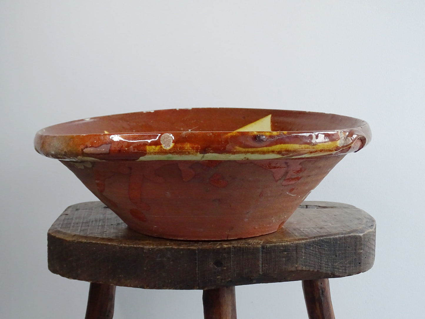 Antique Spanish terracotta bowl or basin with a brown and yellow glaze to the interior. This pottery bowl has a timeworn patina.