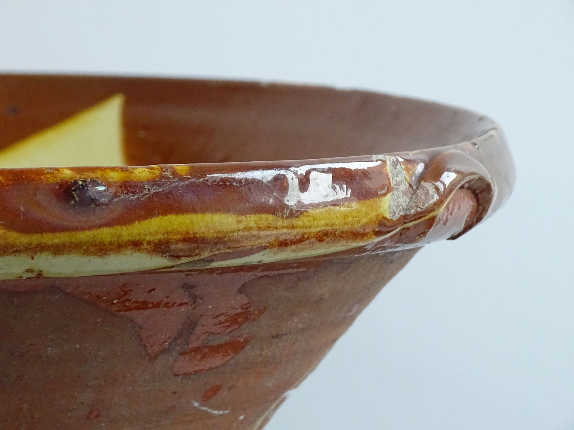 Antique Spanish terracotta bowl or basin with a brown and yellow glaze to the interior. This pottery bowl has a timeworn patina.