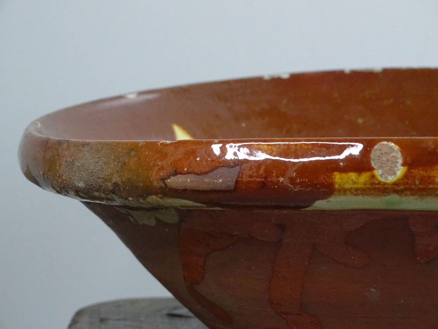 Antique Spanish terracotta bowl or basin with a brown and yellow glaze to the interior. This pottery bowl has a timeworn patina.