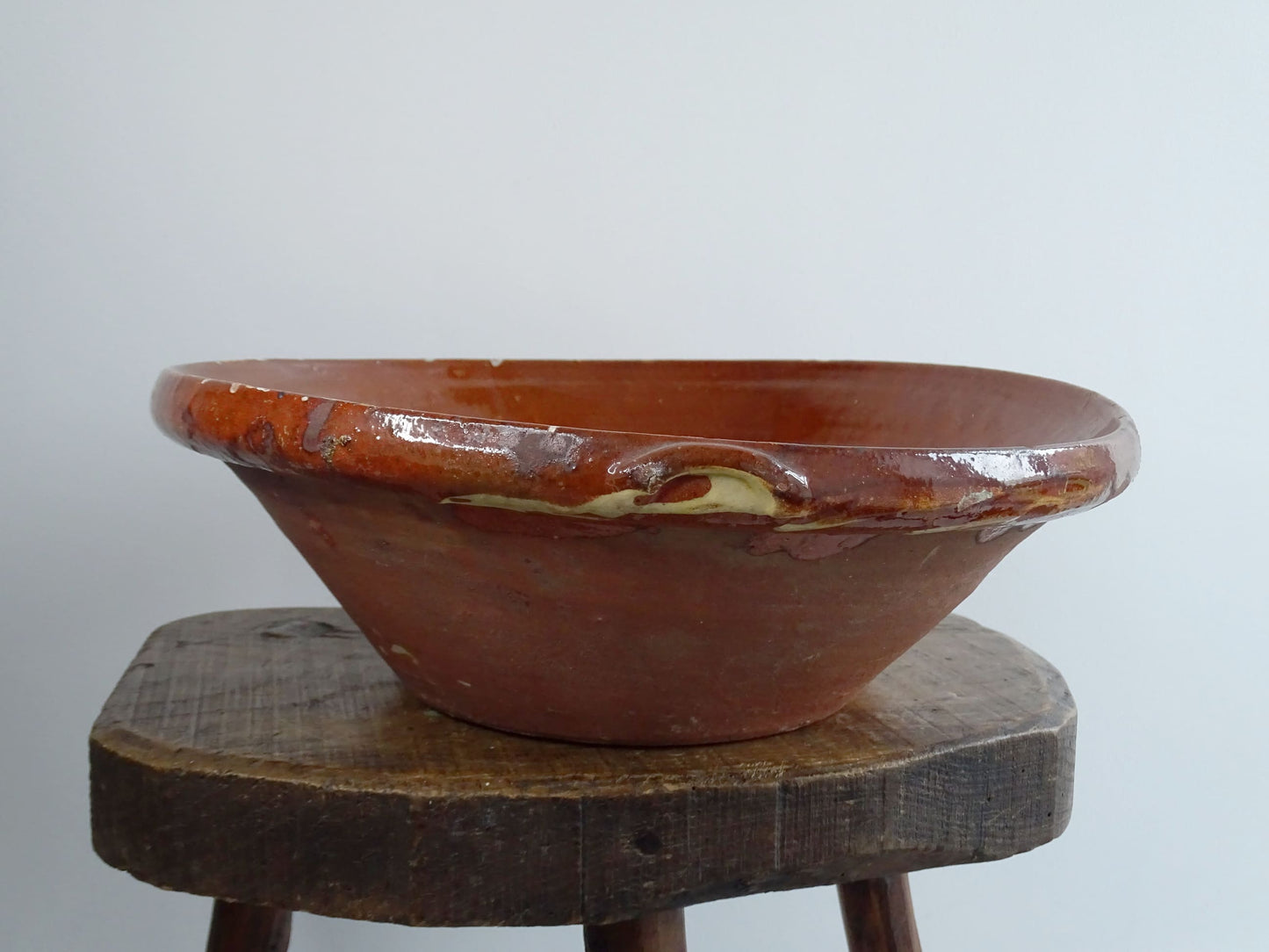 Antique Spanish terracotta bowl or basin with a brown and yellow glaze to the interior. This pottery bowl has a timeworn patina.