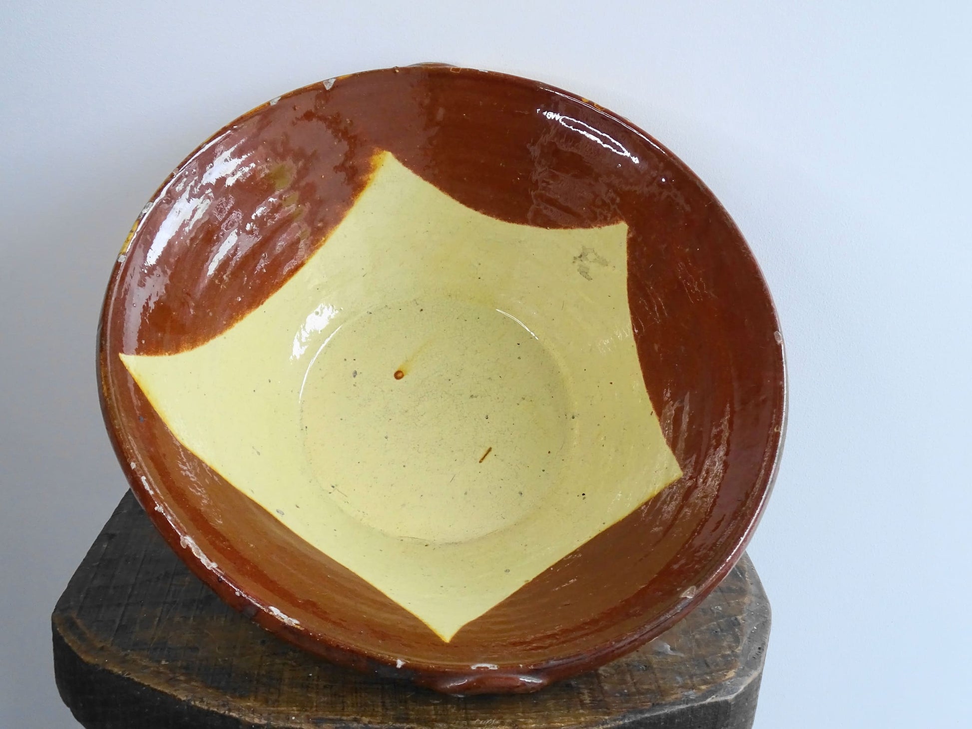 Antique Spanish terracotta bowl or basin with a brown and yellow glaze to the interior. This pottery bowl has a timeworn patina.