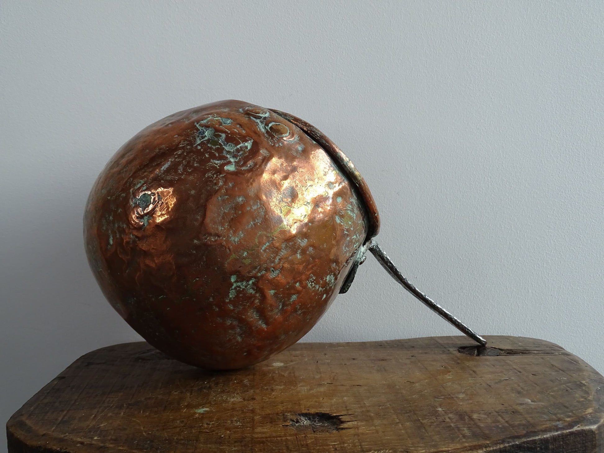 French antique copper zabaglione pan with a curved base, rustic dents, and a rich patina, ideal as a copper kitchen accent in a French farmhouse kitchen, displayed hanging or on a shelf alongside vintage cookware.