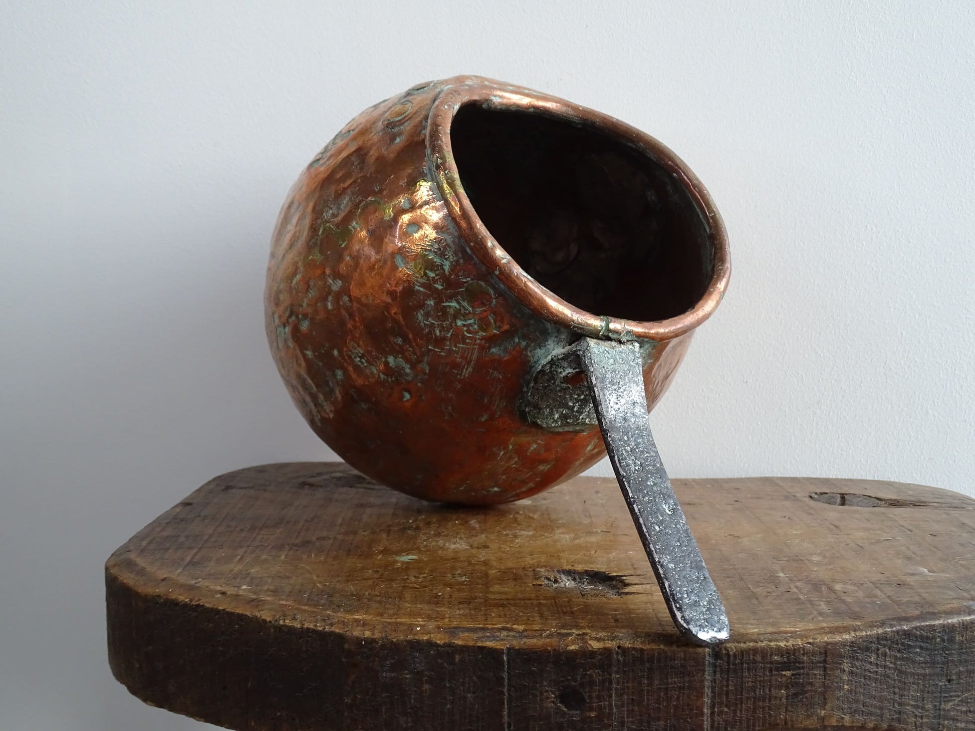 French antique copper zabaglione pan with a curved base, rustic dents, and a rich patina, ideal as a copper kitchen accent in a French farmhouse kitchen, displayed hanging or on a shelf alongside vintage cookware.