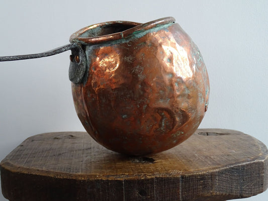 French antique copper zabaglione pan with a curved base, rustic dents, and a rich patina, ideal as a copper kitchen accent in a French farmhouse kitchen, displayed hanging or on a shelf alongside vintage cookware.