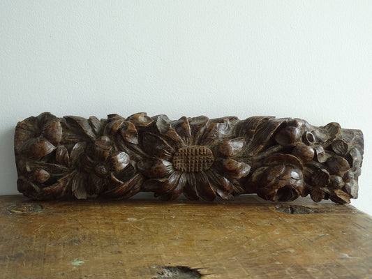 French antique wooden carving with sunflowers and roses. Old wood carving for display.