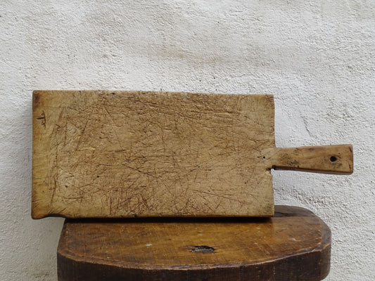 Rustic French antique wooden chopping board with a long handle. Cutting board for a French farmhouse style kitchen