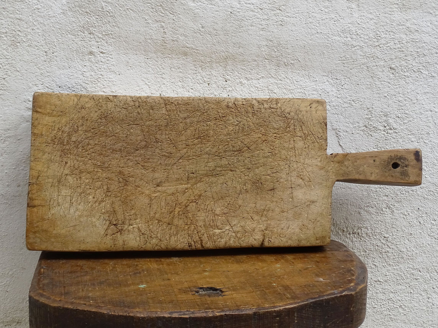 Rustic French antique wooden chopping board with a long handle. Cutting board for a French farmhouse style kitchen