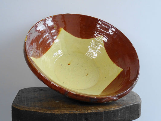 Spanish antique terracotta bowl or basin with a brown and yellow glaze to the interior. This pottery bowl has a timeworn patina.